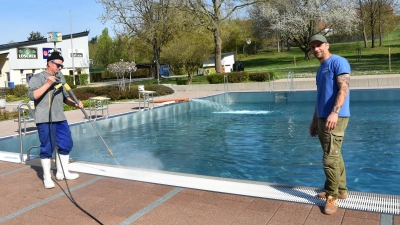 Während das Schwimmerbecken gefüllt wird, legt Günther Kellermann (links) mit dem Dampfstrahler Hand an. Betriebsleiter und Schwimmmeister Julian Lindner (rechts) freut sich auf eine sonnige Saison. (Foto: Anita Dlugoß)