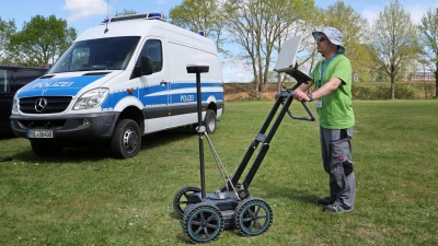 Experten suchen das Grundstück ab. (Foto: Bernd Wüstneck/dpa)