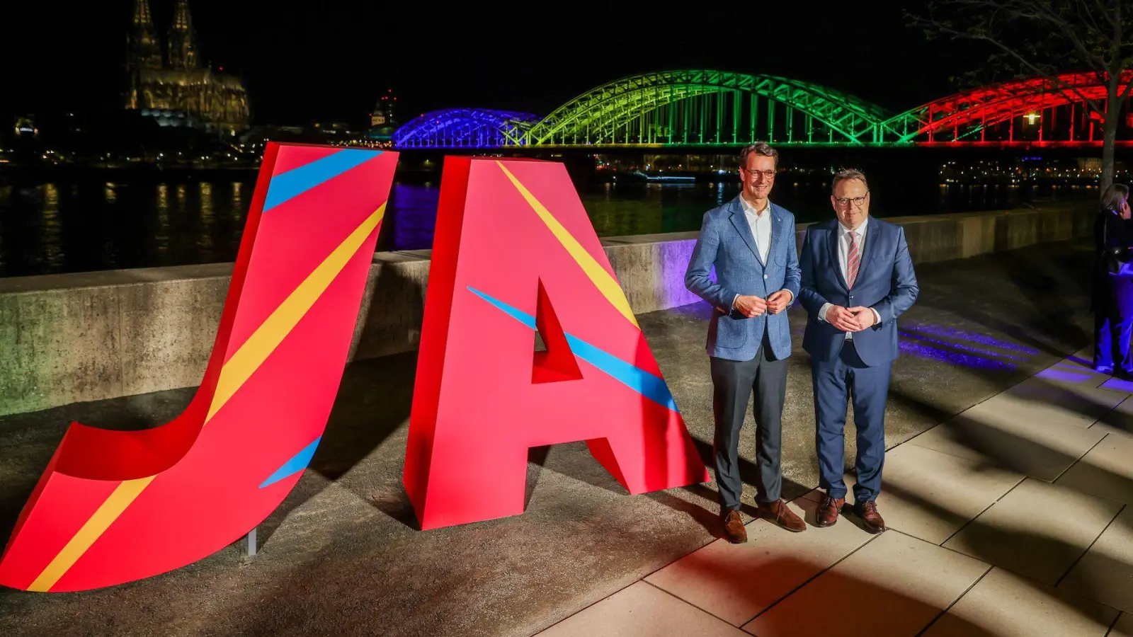 Ministerpräsident Hendrik Wüst (l) und Kölns Oberbürgermeister Torsten Burmester freuen sich über das Ja beim Olympia-Entscheid. (Foto: Christoph Reichwein/dpa)