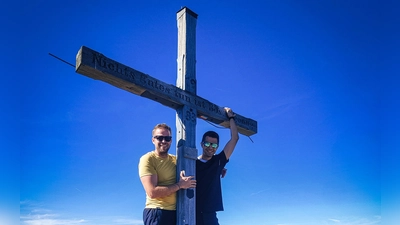 Das 1983 von Bergfreunden aus dem Rothenburger Raum auf den Rosskopf-Gipfel gesetzte Kreuz steht noch. Steffen Heidingsfelder (links) und Franz Lindner haben es in gutem Zustand vorgefunden. Der ins Holz eingeritzte Sinnspruch lautet „Nichts Gutes tun ist Böses genug“. (Selbstauslöserfoto: Steffen Heidingsfelder)