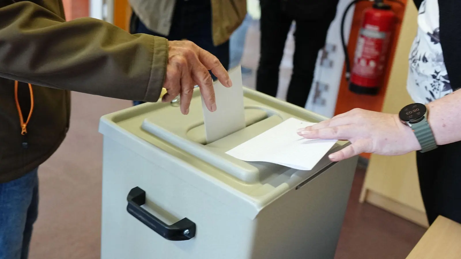 Ein Wähler wirft seinen gefalteten Stimmzettel in die Wahlurne in einem Wahllokal. (Foto: Kay Nietfeld/dpa)