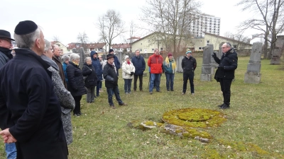 Am Abschlusstag der Woche der Brüderlichkeit führte Historiker Alexander Biernoth (rechts) etwa 25 Besucher über den jüdischen Friedhof und skizzierte dessen Geschichte. (Foto: Florian Pöhlmann)