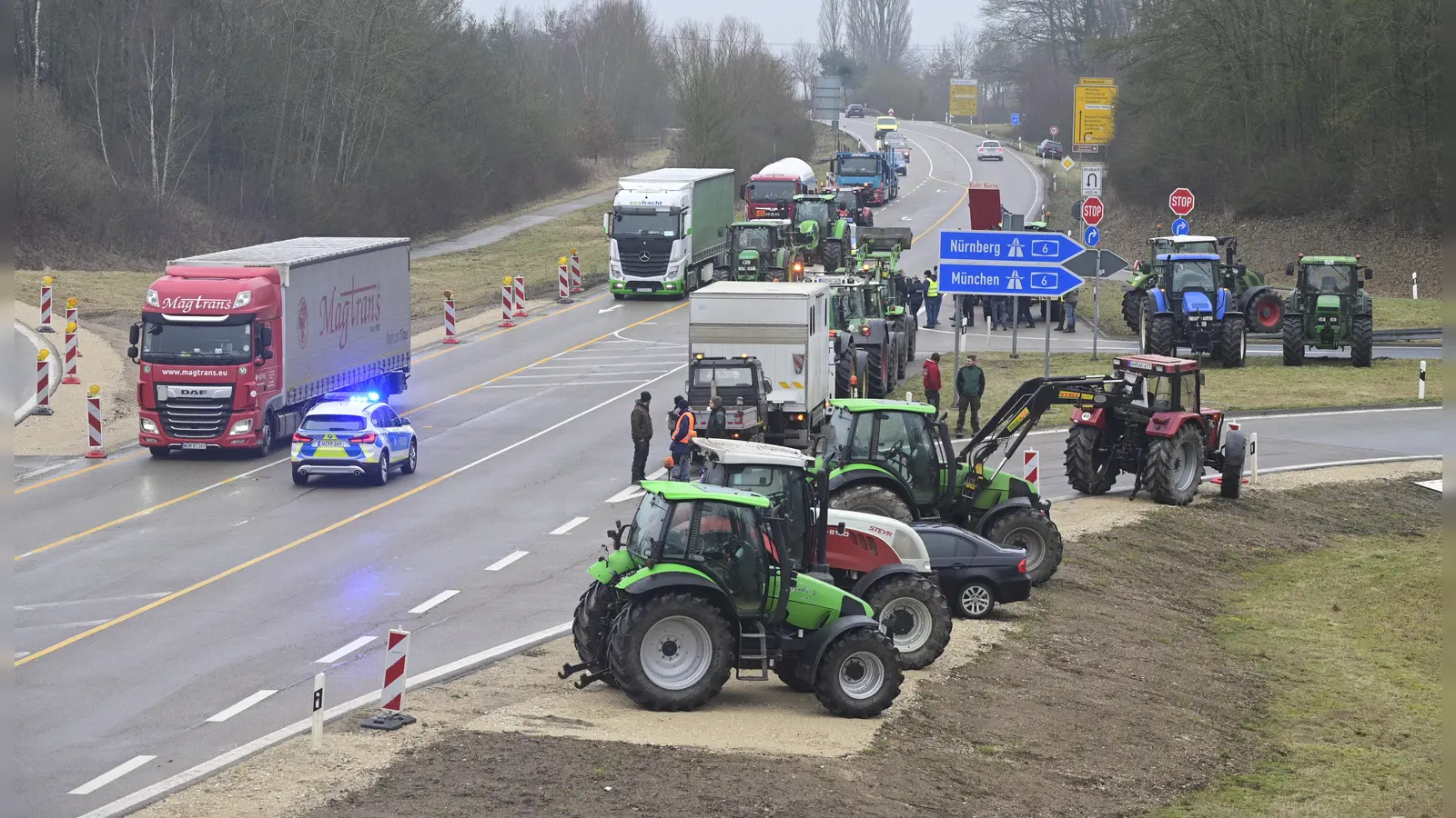 Traktoren auf dem Seitenstreifen und auf der Fahrbahn, dazu Blaulicht: Während der Proteste der Landwirte brauchen Lkw- und Autofahrer Geduld. (Foto: Jim Albright)