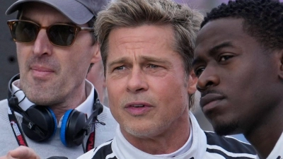 Bild von den Dreharbeiten im Sommer 2023 in Silverstone: Brad Pitt (Mitte) spricht mit Schauspielkollege Damson Idris (rechts). (Archivbild) (Foto: Luca Bruno/AP/dpa)