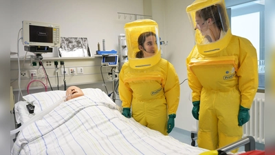 In Schutzanzügen arbeiten die Ärzte auf der Sonderisolierstation am Patienten - hier eine Puppe. (Foto: Malin Wunderlich/dpa)