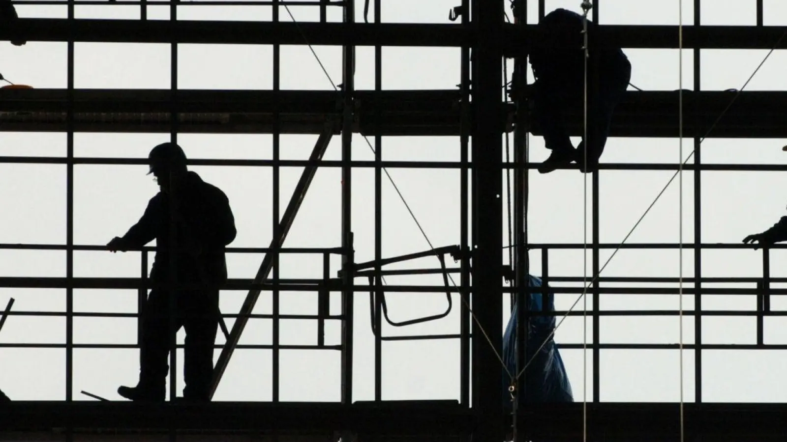 Arbeiter montieren auf einem Gerüst die Glasfassade des Bahnhofs von Frankfurt am Main. (Foto: picture alliance / dpa)