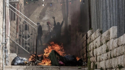 Palästinenser zünden in der Altstadt von Jerusalem einen Mülleimer an. (Foto: Ilia Yefimovich/dpa)