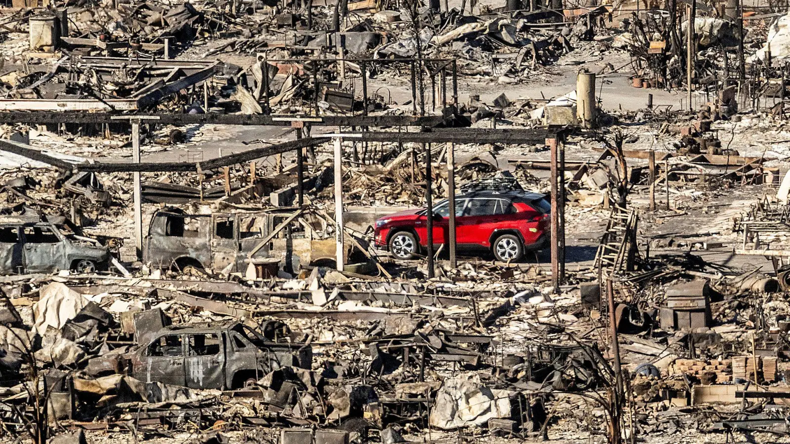 Ein rotes Auto inmitten von Trümmern: Nach den Bränden in Los Angeles. (Foto: Noah Berger/AP/dpa)