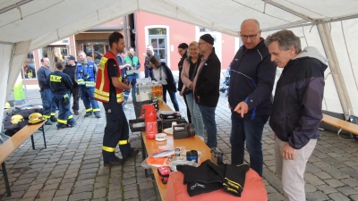 Wie sollten sich die Bürgerinnen und Bürger persönlich auf einen totalen Blackout vorbereiten? Empfehlungen dazu bot das THW-Team am Donnerstagabend in einem Informationszelt auf dem Marktplatz an. Näheres dazu erklärte Zugführer Christopher Beckler (vorne links) den Interessierten. (Foto: Peter Zumach)