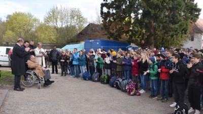 Mit Applaus wurde der eigentliche Hausherr von Schloss Schwarzenberg, Fürst Karl von Schwarzenberg (im Rollstuhl), von den Mädchen und Buben der Schlossschulen sowie von den Teilnehmern des Deutsch-Tschechischen Gesprächsforums – darunter dessen beide Vorsitzenden Christian Schmidt (links) und Libor Rouček (im hellen Mantel) – willkommen geheißen. (Foto: Andreas Reum)