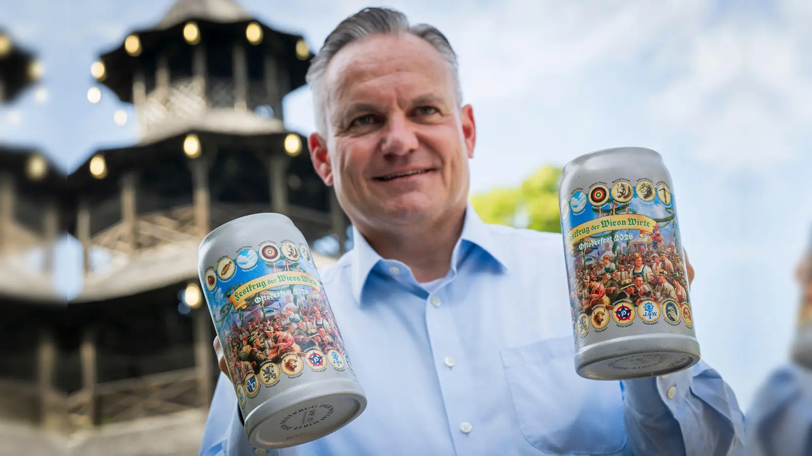Wiesnchef Christian Scharpf zeigt den aktuellen Maßkrug der Wiesnwirte. (Foto: Peter Kneffel/dpa)