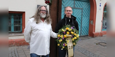 Hannes Hüttinger (links) hat mit Axel Ludwig Setzer einen Kranz für Robert Limpert vor dem Ansbacher Rathaus niedergelegt. (Foto: Alexander Biernoth)