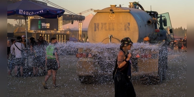 Um den Staub zu binden, waren Traktoren mit großen Wasserfässern unterwegs und befeuchteten den Boden. Manche Fans nutzten die Gelegenheit, um sich abzukühlen.  (Foto: René Chlopotowski)