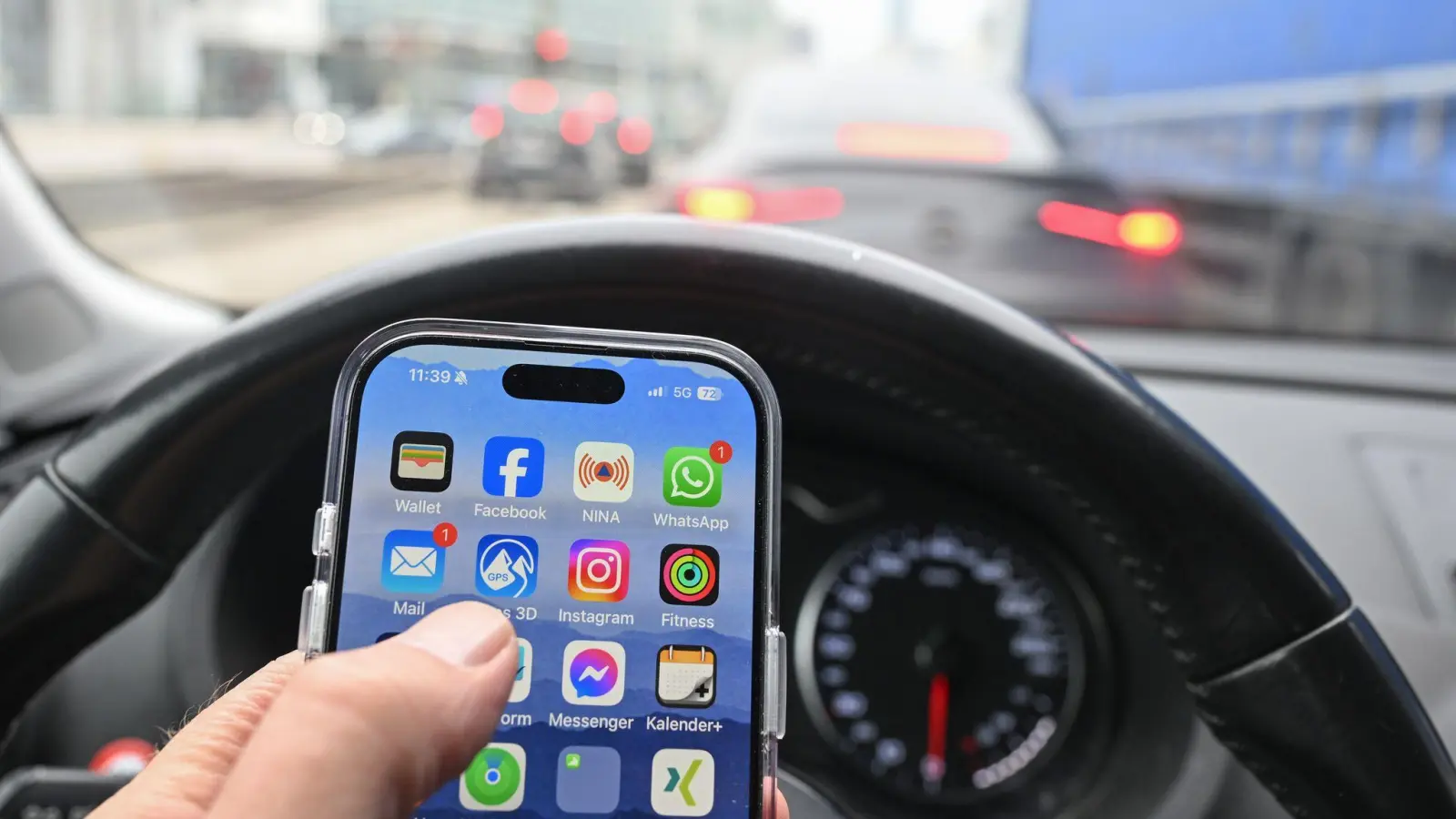 Nein, schlechte Idee: Wer im Auto ein Smartphone nutzen will, fährt besser rechts ran - und schaltet den Motor ab. Sonst könnte es teuer werden - gefährlich allemal. (Foto: Bernd Weißbrod/dpa)