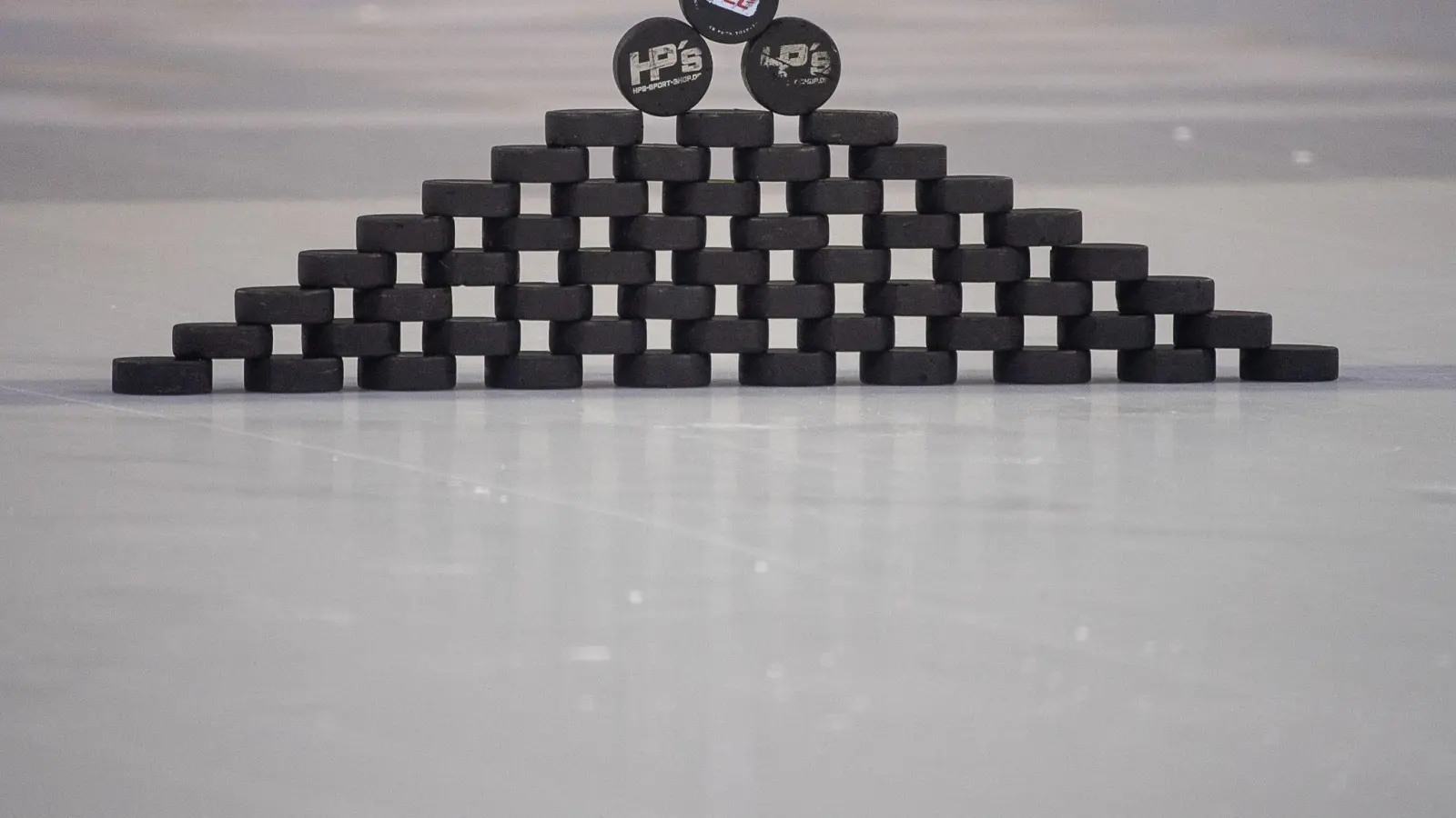 Ein Puck mit dem Logo der Deutschen Eishockey Liga (DEL) liegt auf weiteren Pucks. (Foto: Sebastian Gollnow/dpa/Symbolbild)