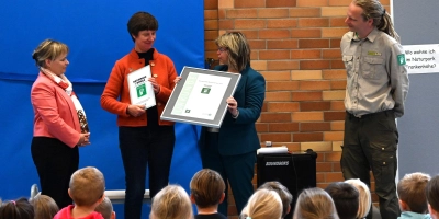 Claudia Wust, Bürgermeisterin und Vorsitzende des Schulverbands, und Schulleiterin Kerstin Stiegler bekommen von Renate Hans, der Vorsitzenden des Naturparks Frankenhöhe (von links), die Urkunde als Naturpark-Schule und ein Schild für den Eingang. Aufmerksame Beobachter sind Ranger Benjamin Krauthahn und die Kinder der Grundschule. (Foto: Manfred Blendinger)