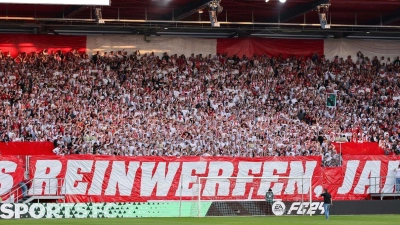 Die Regensburger Fans haben eine Choreo mit dem Spruch „Alles reinwerfen, Jahnelf!“ aufgehangen. (Foto: Daniel Löb/dpa)
