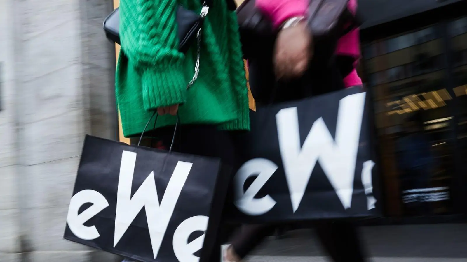 Frauen mit KaDeWe-Tragetaschen gehen am Eingang des Kaufhauses des Westens vorbei. (Foto: Jörg Carstensen/dpa)