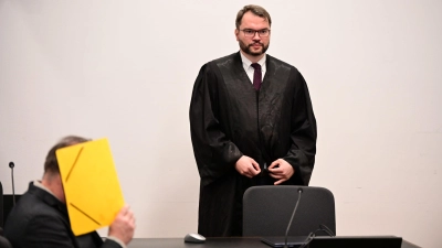 Vor Prozessbeginn verbarg der 55-jährige Angeklagte sein Gesicht hinter einem Aktendeckel. Stehend sein Pflichtverteidiger Johann Bund.  (Foto: Udo Güldner)