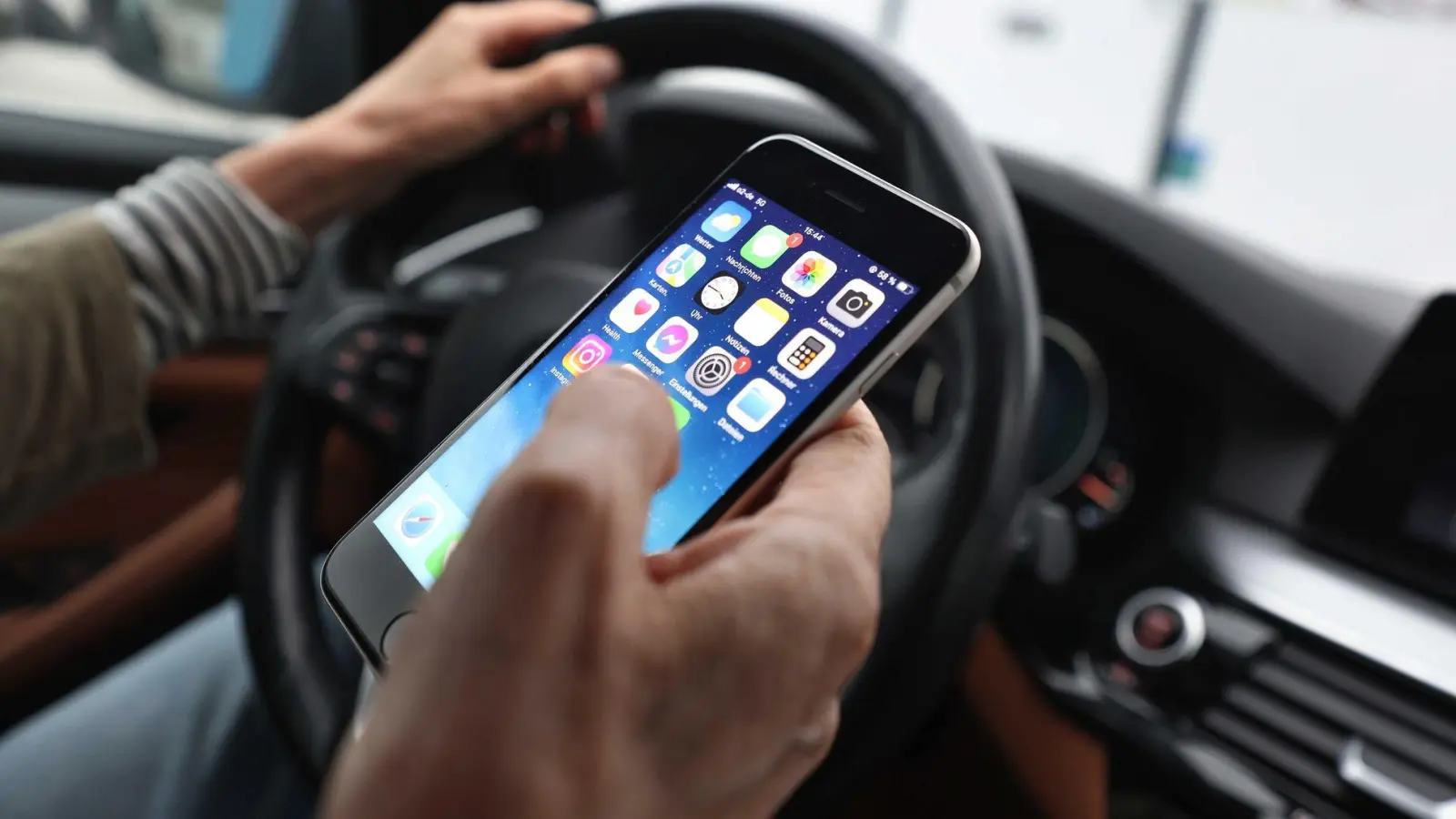 Ein „kurzer“ Blick auf das Handy ist bisher erlaubt - wenn man es nicht in die Hand nimmt. (Symbolbild) (Foto: Karl-Josef Hildenbrand/dpa)