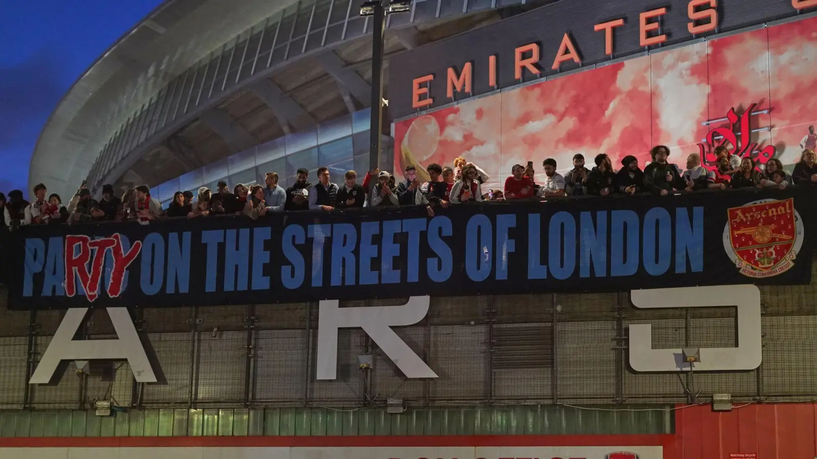 Arsenal-Fans zeigen nach dem Titelgewinn ein Banner am Stadion: „Party auf Londons Straßen“ (Foto: Alberto Pezzali/AP/dpa)