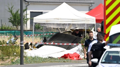 Sicherheitskräfte untersuchen das Wrack eines zivilen Flugzeugs. (Foto: Jean-Christophe Verhaegen/AFP/dpa)