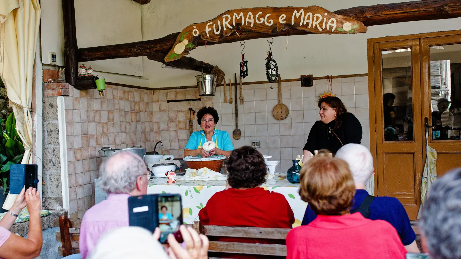 Bäuerin Maria (links) präsentiert ihren selbst geflochtenen Mozzarella-Käse. (Foto: Tizian Gerbing)