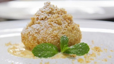 Puderzucker, süße Streusel - und drinnen die Sommerfrucht: Marillenknödel sind eine Genießer-Süßspeise. (Foto: Beate Wöllstein/Wöllsteins Desserthaus/dpa-tmn)