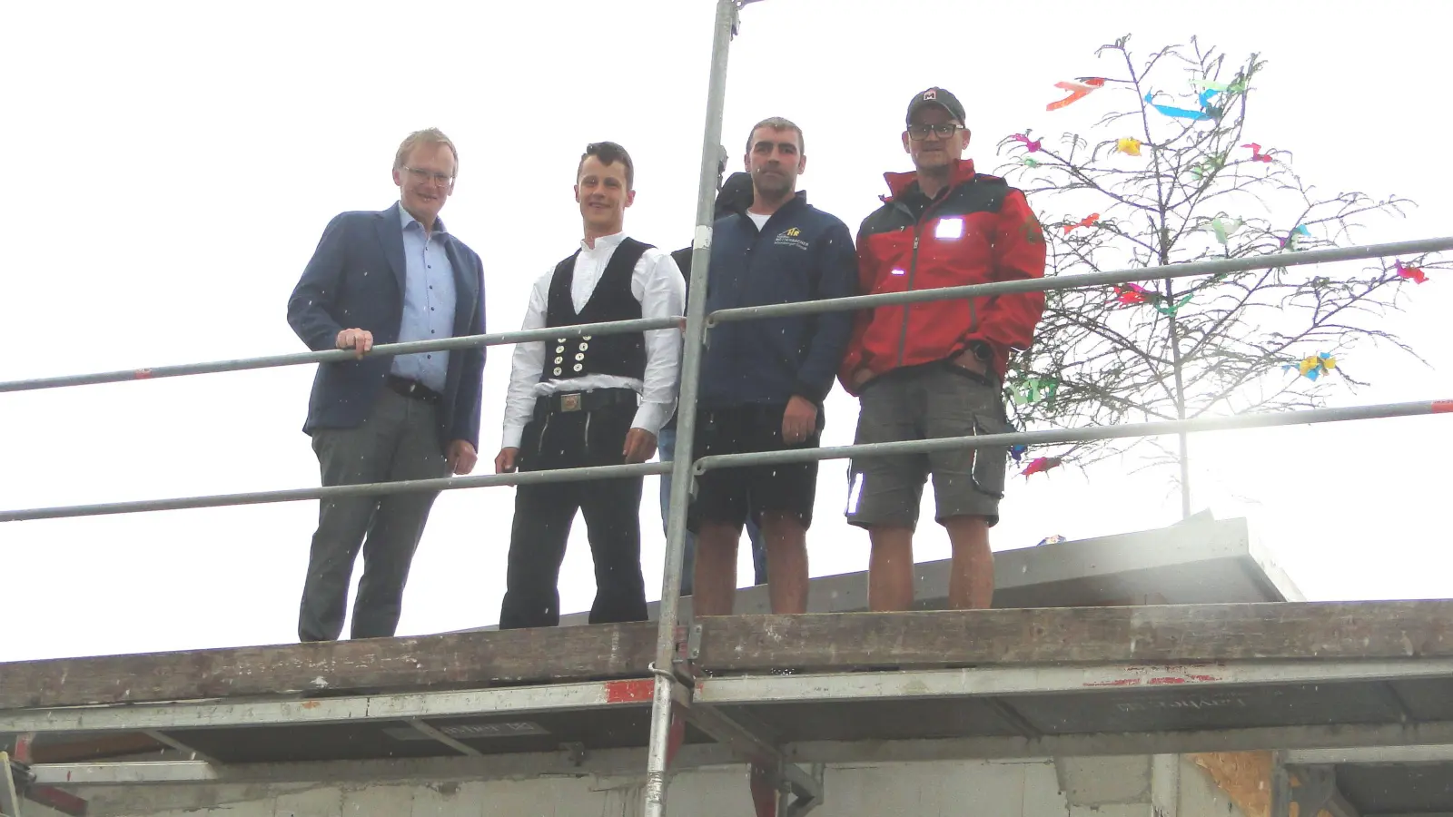 Bürgermeister Gerhard Wachmeier (links) steht beim Richtfest auf dem Dach des neuen Colmberger Feuerwehrhauses, das bis Ende des Jahres fertiggestellt werden soll. (Foto: Winfried Vennemann)