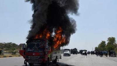 Rauch steigt aus einem brennenden Bus während Zusammenstößen von Anhängern des ehemaligen pakistanischen Premierministers Khan und der Polizei. (Foto: W.K. Yousafzai/AP/dpa)