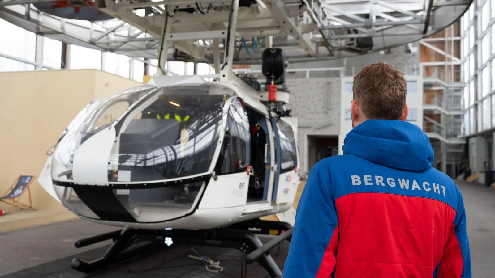 Im Bergwacht-Zentrum für Sicherheit und Ausbildung steht ein Mitglied der Bergwacht Bayern vor einem Hubschrauber-Modell. (Archivbild) (Foto: Magdalena Henkel/dpa)