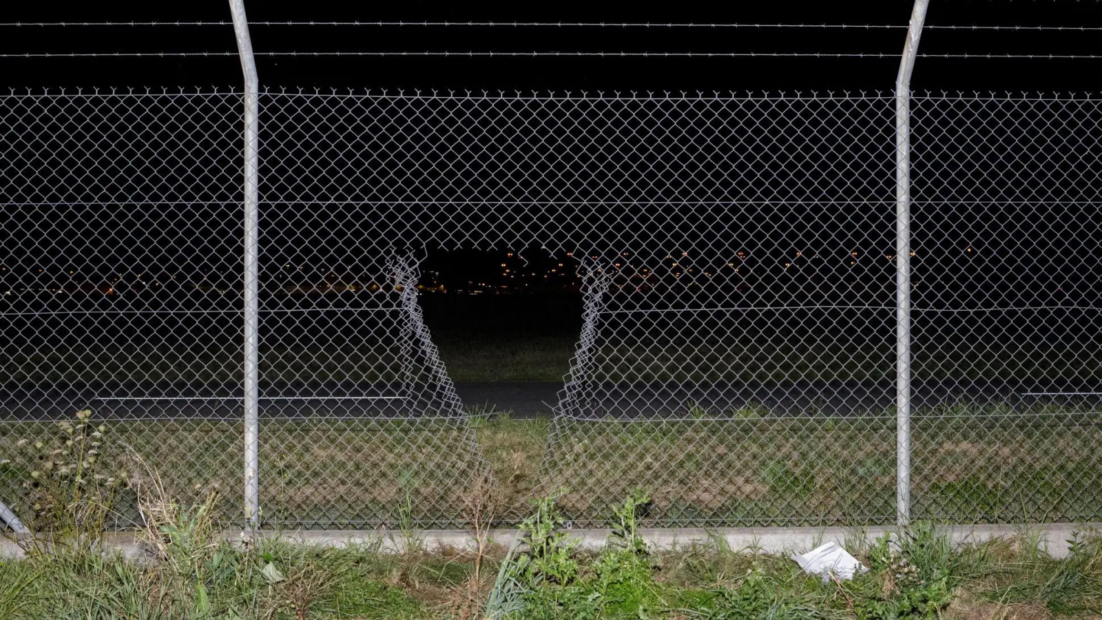 Durch ein Loch im Zaun verschafften sich die Aktivisten Zugang zum Flughafengelände. (Foto: Julius-Christian Schreiner/dpa)