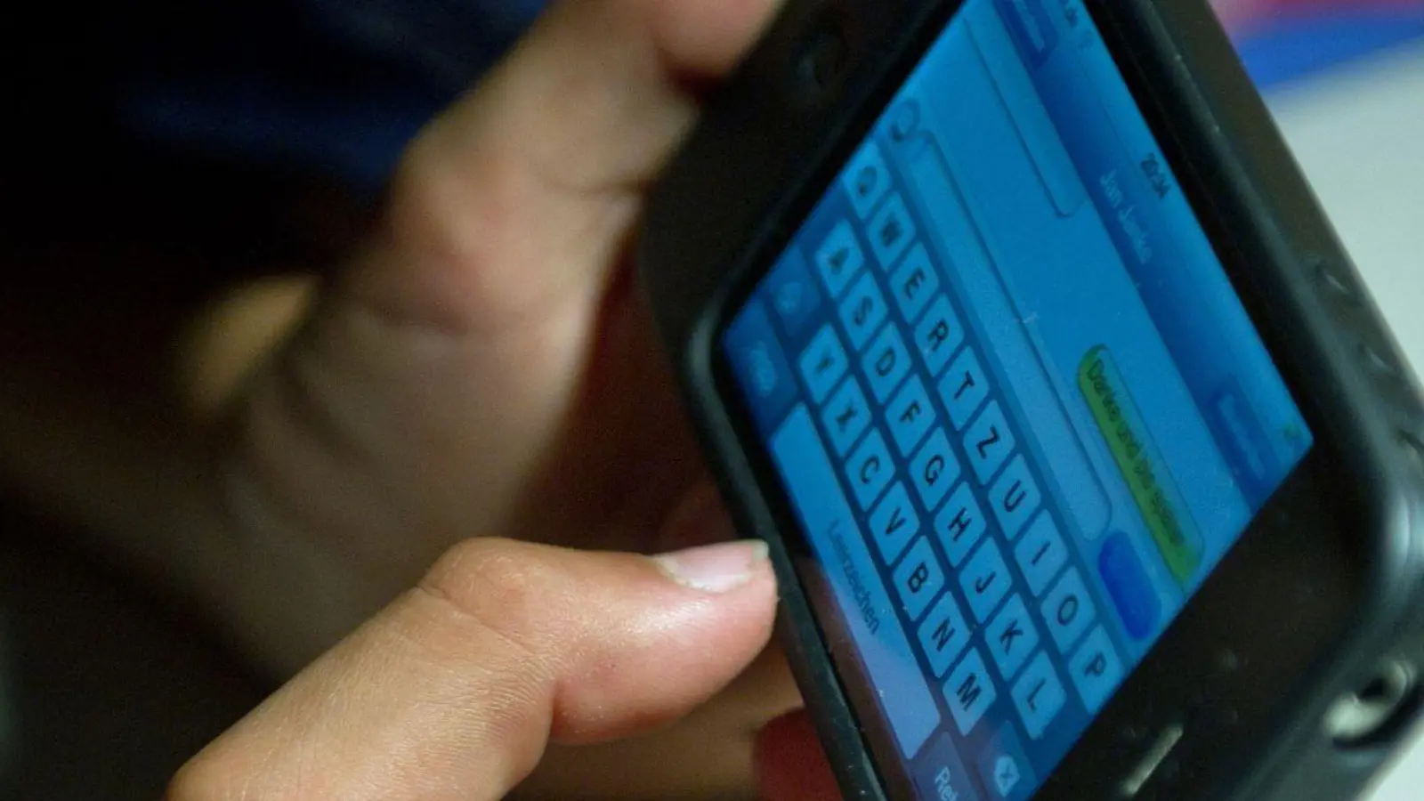 Ein elfjähriger Junge liegt unter der Bettdecke und schreibt auf einem Smartphone eine SMS. Kinder unter 13 Jahren sollten Experten zufolge keinen Zugang zu derartigen Medien haben. (Foto: Patrick Pleul/dpa)