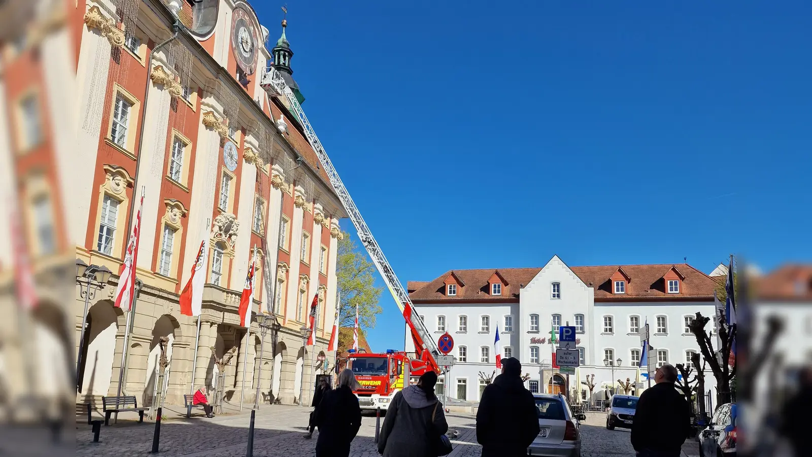 Der ungewöhnliche Einsatz der Feuerwehr an der Rathaus-Uhr in Bad Windsheim erregte bei den vorbeigehenden Menschen große Aufmerksamkeit. (Foto: Josh Reuter)