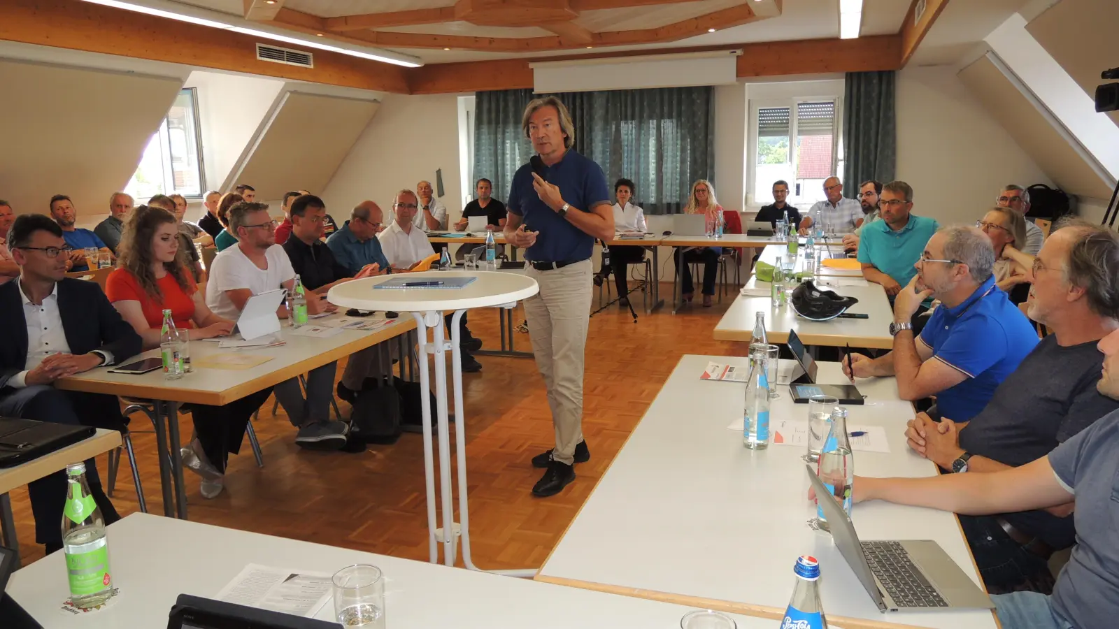 Herriedens Stadträte tagten am Mittwochabend öffentlich im Gemeinschaftshaus in Rauenzell: In der Sitzung, die zahlreiche Bürger als Zuhörer verfolgten, referierte Windkümmerer Erich Maurer (stehend). (Foto: Peter Zumach)