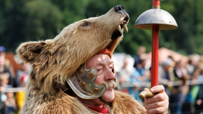 Auf in die Schlacht: Das Varusschlacht-Museum in Bramsche veranstaltet wieder die Römer- und Germanentage. Ein als römischer Legionär verkleideter Darsteller trägt dabei einen Bärenkopf. (Foto: Friso Gentsch/dpa)