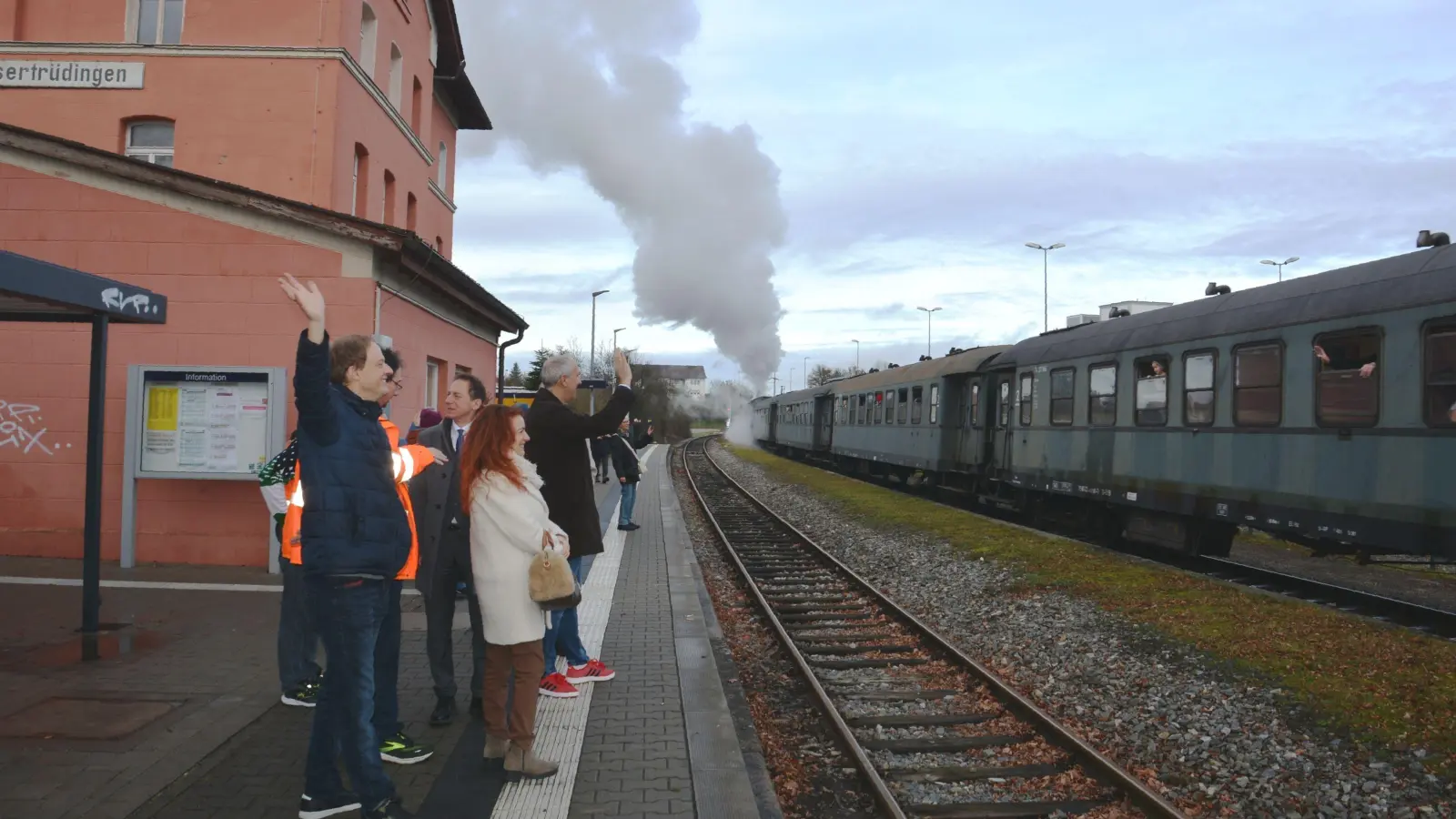 Winkend wird der Nikolaus-Zug am Bahnhof Wassertrüdingen in Richtung Gunzenhausen verabschiedet, links im Vordergrund Peter Banczyk, Sprecher der Initiative Verbindung zwischen Freunden. (Foto: Peter Tippl)