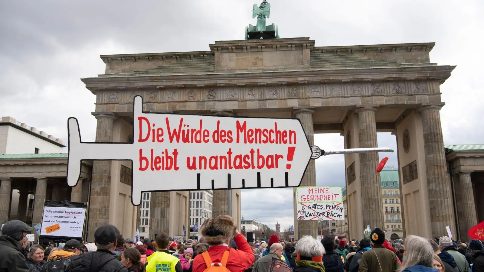 Impfpflicht-Gegner stehen bei einer Kundgebung vor dem Brandenburger Tor in Berlin, während der Bundestag über die Einführung einer Impfpflicht debattiert. (Foto: Paul Zinken/dpa)