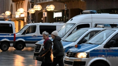 Polizisten kontrollieren am Eingang des Kölner Doms den Beginn der Frühmesse am Weihnachtstag. (Foto: Roberto Pfeil/dpa)