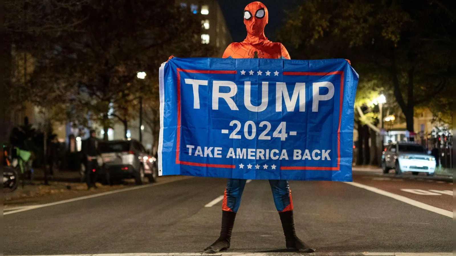 Trump-Unterstützer im Spider-Man-Kostüm mit einem Trump-Transparent am Tag der US-Präsidentschaftswahl 2024 in Washington. (Foto: Probal Rashid/ZUMA Press Wire/dpa)