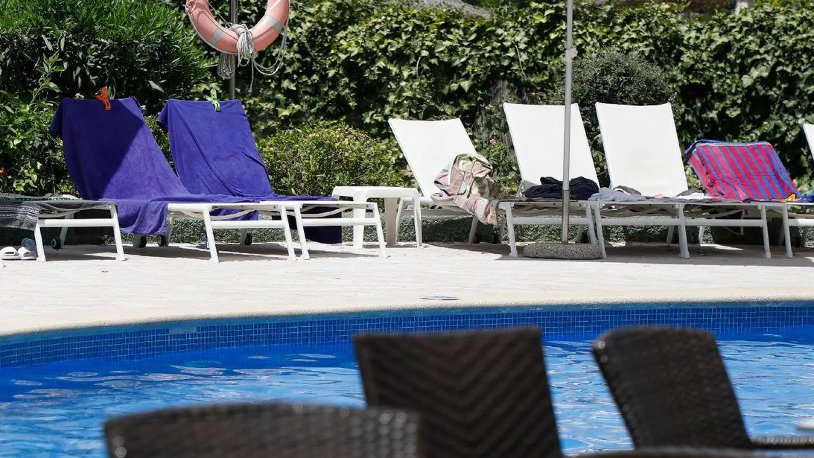 Handtücher liegen auf Sonnenliegen an einem Pool auf Mallorca. (Symbolbild) (Foto: Clara Margais/dpa)