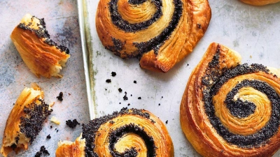 Der Plunderteig für die Mohnschnecken aus Teig- und Butterschichten sollte so oft gefaltet werden, dass er am Ende 27 Butterschichten erhält. (Foto: Hubertus Schüler/BJVV/Hubertus Schüler/BJVV/dpa)