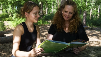 „KiPrax”-Praktikantin Zuhra Murati (links) bespricht ein Bilderbuch mit ihrer Praxisanleiterin Sandra Besold. (Foto: Tobias Völker)