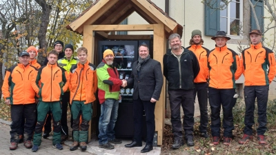 Landwirt Heiko Stettner (Mitte links) und Forstbetriebsleiter Florian Vogel (Mitte rechts) weihten den Wildfleisch-Automaten gemeinsam mit Ausbildungstrainer Franz Wenk (links) und Forstwirtschaftsmeister Hartmut Klosch (rechts vom Automaten) sowie den Auszubildenden des Forstbetriebs ein. (Foto: Hannah Ströbel)