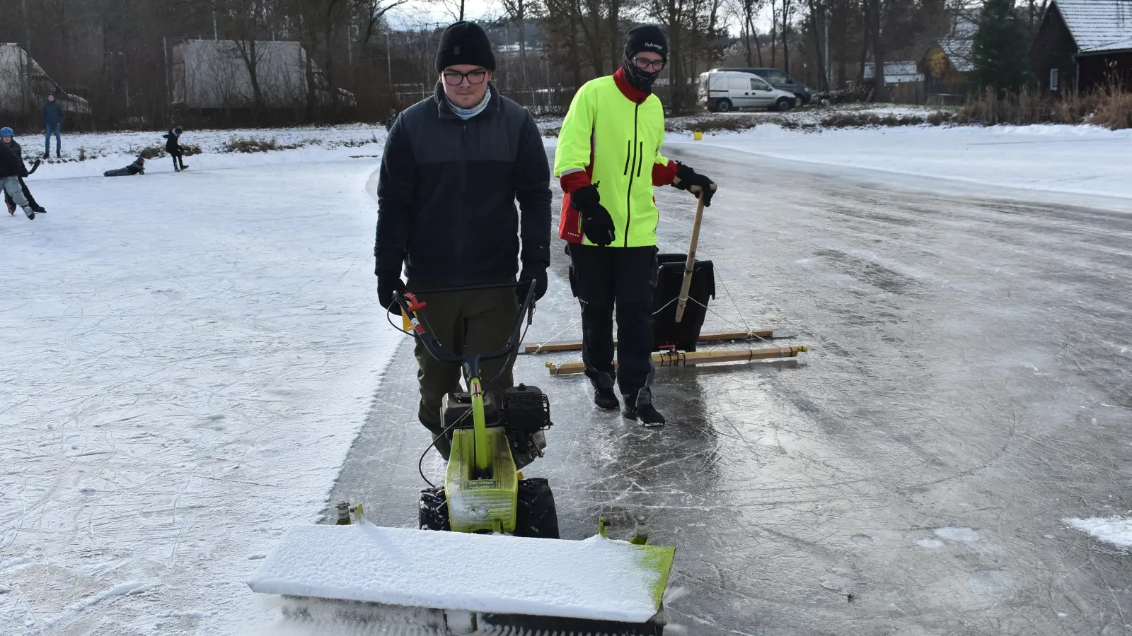 Luca Bauer (links) und Jonas Grünbaum befreien den Eisweiher mit ihren teils selbst konstruierten Geräten vom störenden Schnee. (Foto: Ute Niephaus)