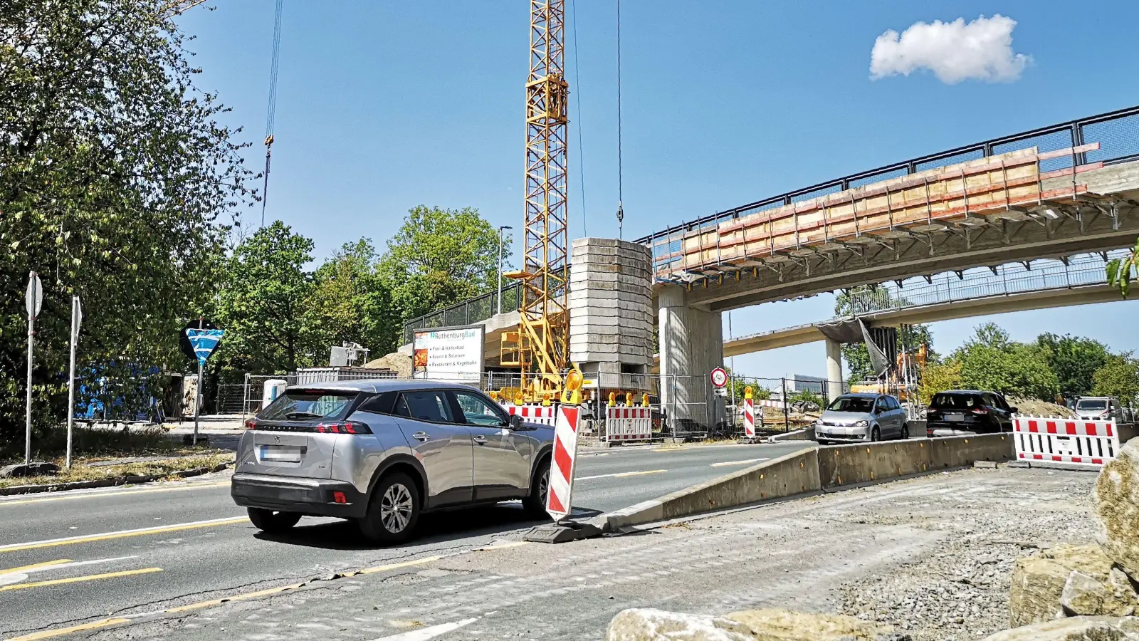 Noch ist im Brückenbereich die Durchfahrt mit zehn Stundenkilometern möglich. Ab Montag, 17. August, kommt es dort dann aber zu einer zweiwöchigen Vollsperrung, weil das alte Bauwerk (hinten) abgerissen wird. Im Vordergrund ist die neue Brücke zu sehen. (Foto: Jürgen Binder)