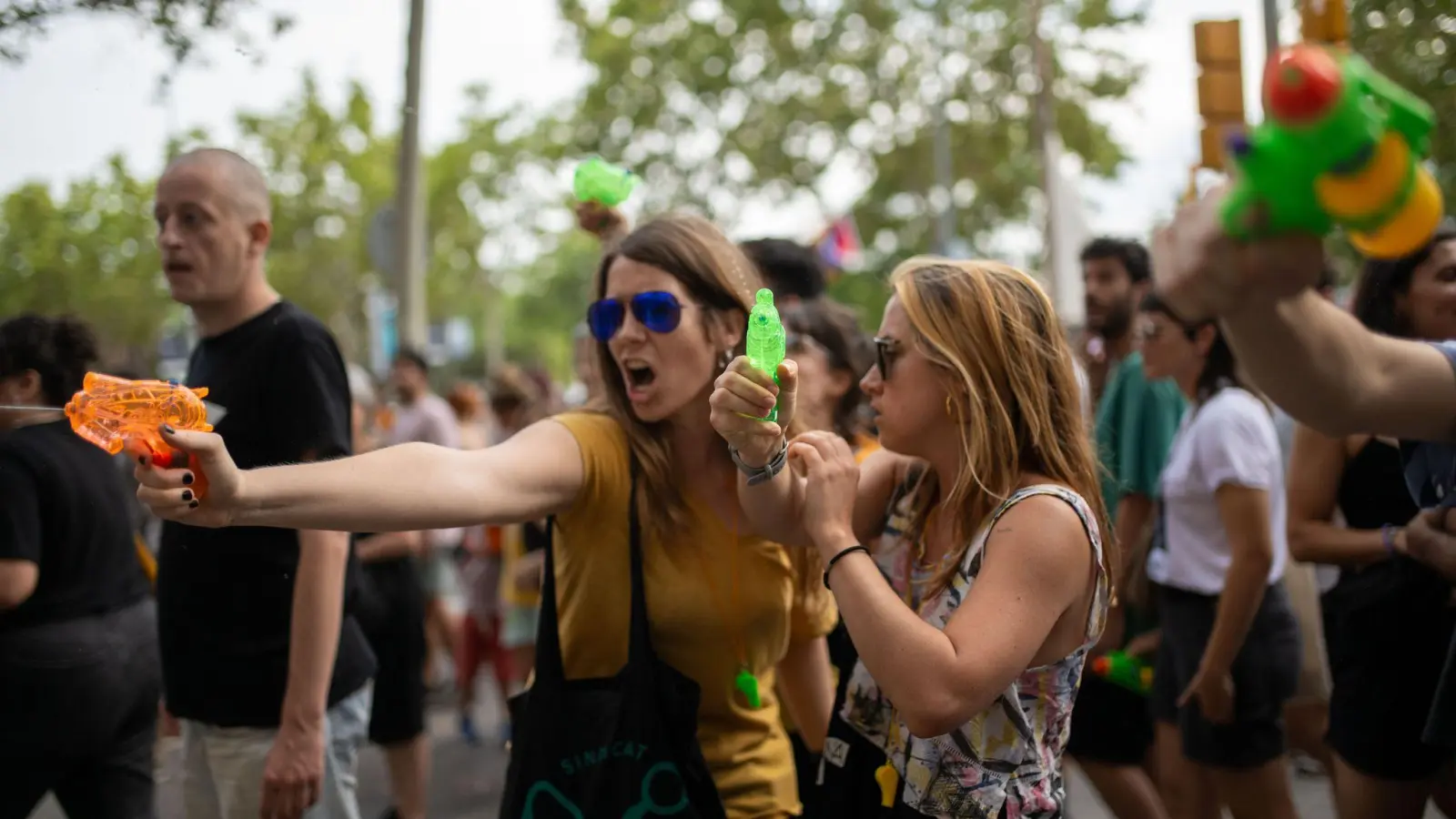 Demonstrantinnen verpassen Urlaubern eine unerbetene Abkühlung aus Wasserpistolen. (Foto: Lorena Sopêna/EUROPA PRESS/dpa)