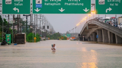 Ein Mann watet durch die Fluten in einem Vorort von Hat Yai in Thailand. (Foto: -/XinHua/dpa)