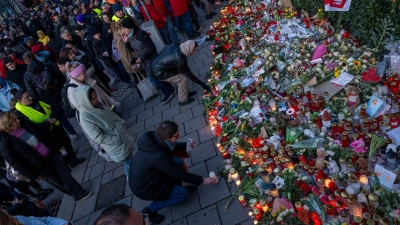 Teilnehmer einer Verdi-Gedenkveranstaltung für die Opfer des Anschlags auf eine Demonstration legen Kerzen, Blumen und Karten ab.  (Foto: Peter Kneffel/dpa)