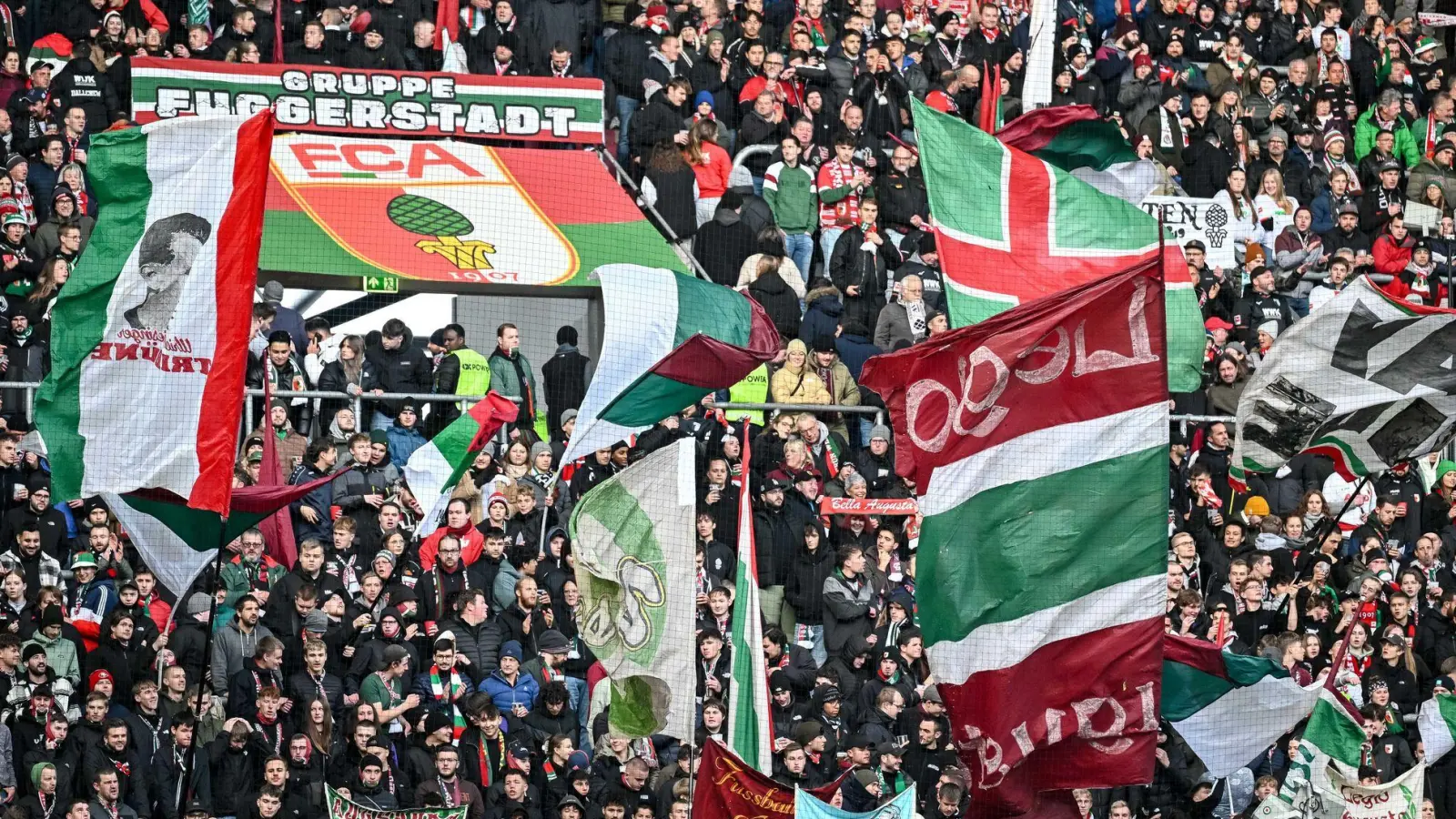 Fans des FC Augsburg schwenken ihre Fahnen in der WWK-Arena. (Archivfoto) (Foto: Harry Langer/dpa)